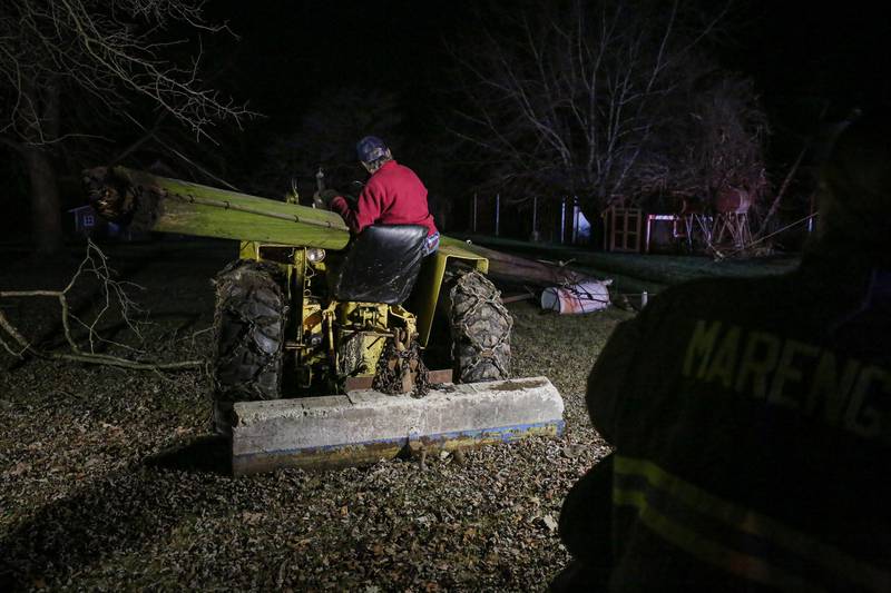 Firefighters were able to free a man without injury who was trapped in a tractor after a utility pole collapsed onto him Monday evening near Marengo, officials report.