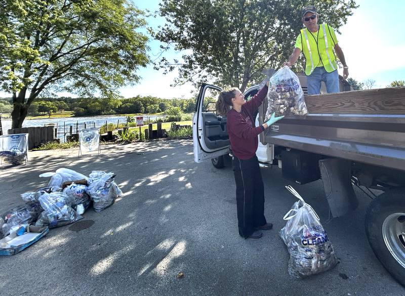 Mike Long hands a bag of trash to Melanie Cozzi during the Rock River Sweep on Saturday, Sept. 6, 2025. Volunteers collected trash from the river and its banks from Mud Creek Road to Castle Rock State Park.