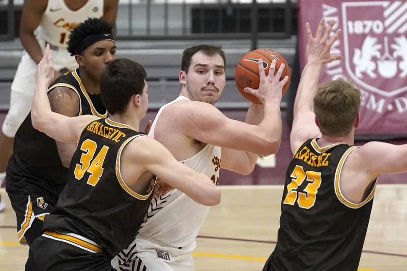 Loyola Chicago's Cameron Krutwig, center, looks to pass as Valparaiso's Jacob Ognacevic (34) and Ben Krikke defend during the second half of an NCAA college basketball game Wednesday, Feb. 17, 2021, in Chicago. Loyola Chicago won 54-52. (AP Photo/Charles Rex Arbogast)