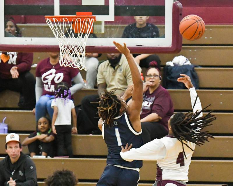 Morton East's Twon Jones (4) makes a basket while being defended by Downers Grove South's Keon Maggitt (1) in the first quarter on Saturday Dec. 9, 2023 held at Morton East High School.