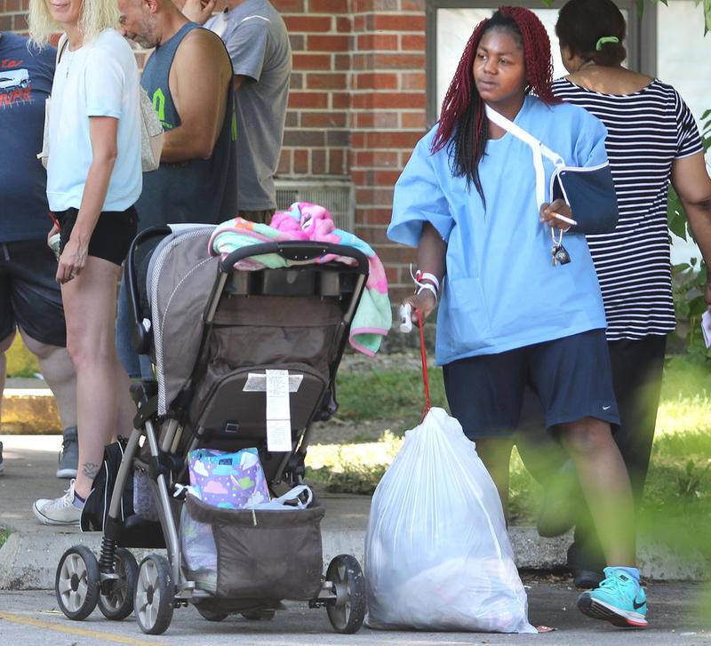 Dominique Warner gathers some belongings from her unit at Ridgebrook Apartments, 808 Ridge Drive in DeKalb Wednesday morning, less than 24 hours after a fire displaced them from the complex. Warner has filed a lawsuit against building owner Hunter Properties in relation to the fire.