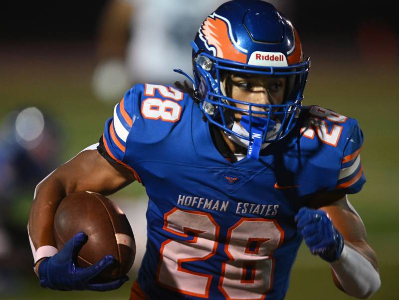 Hoffman Estates’ Landon Ford carries the ball during Friday’s football game against Maine East.