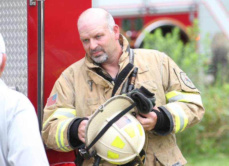 Oglesby fire chief Steve Maltas puts on his helmet while arriving to a structure fire in the 500 block of North 2782nd Road on Monday, July 21, 2025 in La Salle. FIre departments from Utica, Wallace, Naplate, Spring Valley, Mendota, Troy Grove, La Salle, Peru, Oglesby and Tonica responded to the scene. Fire crews were dispatched at 9:45 a.m. La Salle Police and La Salle County Sheriff were also on the scene.