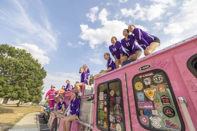 The DHS freshman volleyball team poses for pictures atop the Pink Heals firetruck Thursday, Oct. 2, 2025, outside of the high school. In recognition of Breast Cancer Awareness Month, the teams raised money through donations and sales to donate $500 to Pink Heals and also a donation to a community member battling cancer.