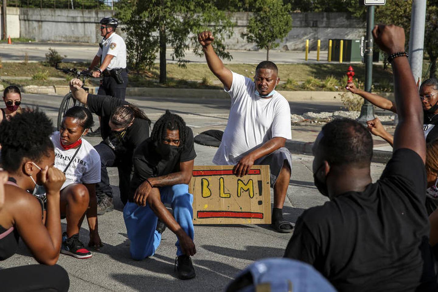 Demonstrators can be seen taking a knee during a moment of silence outside the Will County Courthouse on Saturday, Aug. 22, 2020, in response to the January 28 overdose death of Eric Lurry who died in police custody.