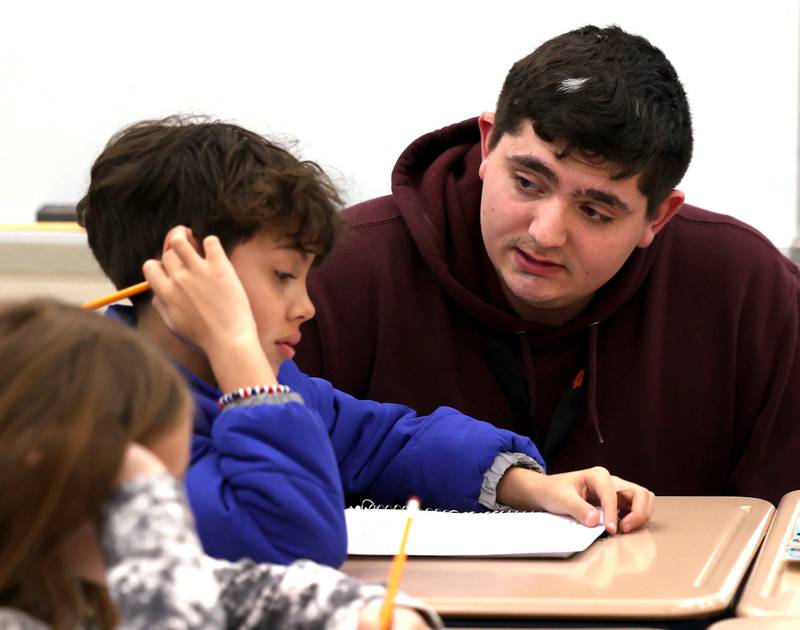 Drew Hoth, former Northern Illinois University football player and current student teacher in District 428, works with a student Thursday, March 20, 2025, at Jefferson Elementary School in DeKalb.