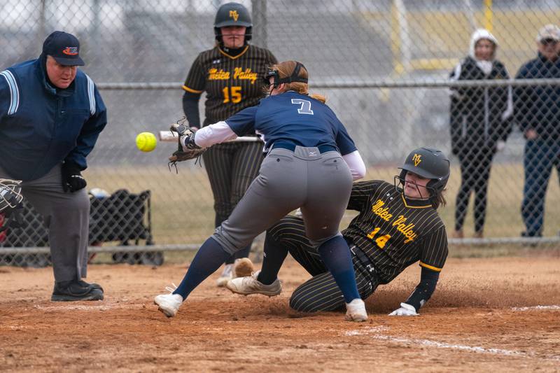 Metea Valley's Macey Martin (14) beats the throw to home to score on a wild pitch against Oswego East during a softball game at Metea Valley High School in Aurora on Friday, Mar 24, 2023.