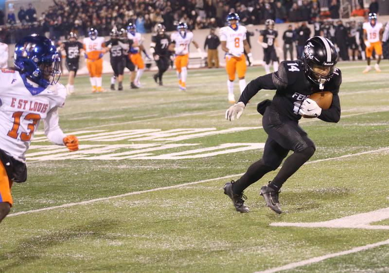 Fenwick's Cameron Garrett takes off into the end zone after catching a pass while East St. Louis's Dekarai Weaver misses the coverage during the Class 6A State championship game on Tuesday, Dec. 2, 2025 in Hancock Stadium at Illinois State University in Normal.