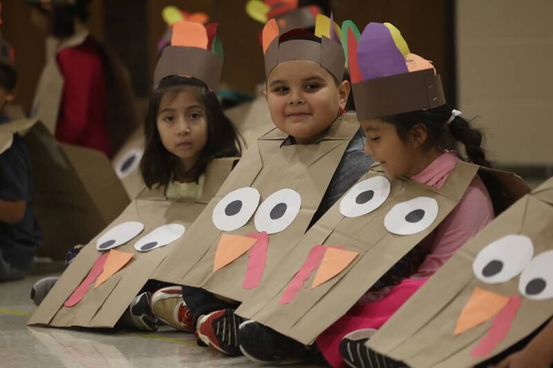 Thomas Jefferson Elementary School kindergartens Victoria Aguilar, left, Alexander Zaragoza and Aliaia Zavala wait for their Thanksgiving treats on Friday.