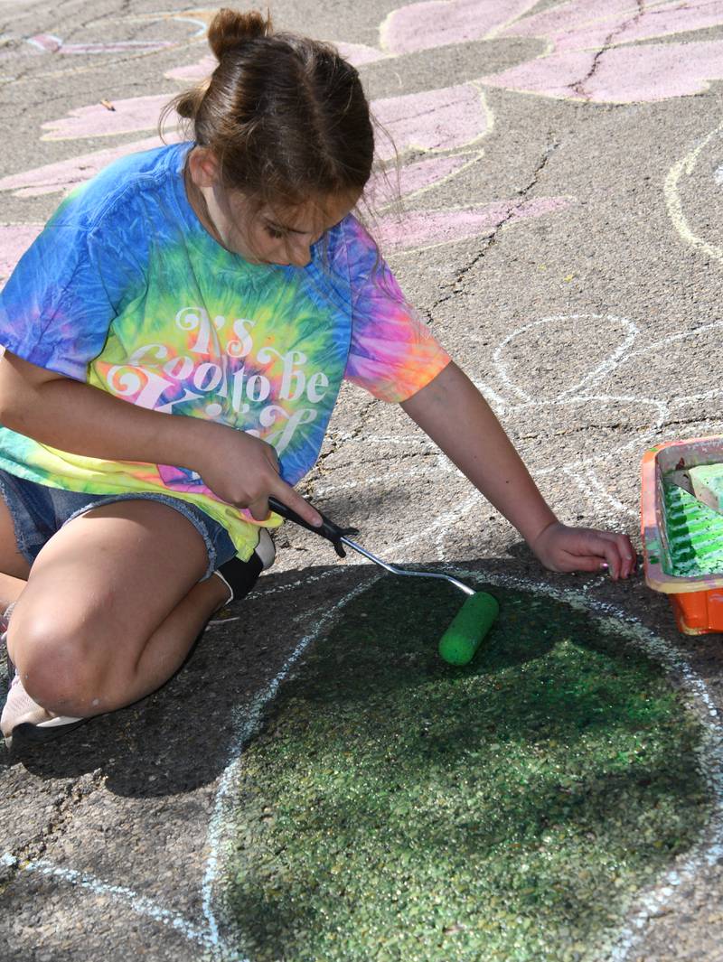 Edith Krabill colors sidewalk chalk drawings Saturday, May 27, 2023, during Sidewalk Chalkapalooza at Soldiers and Sailors Park in Princeton.