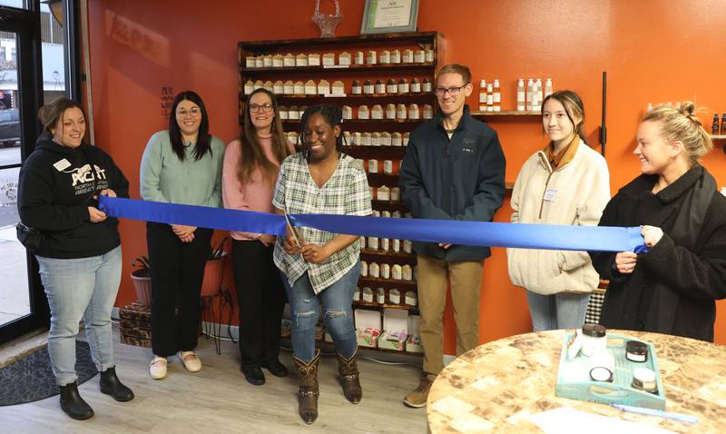 Robin Youngblood (center) cuts the ribbon during a grand opening of RMY Homemade Goods Natural Skin Care on Tuesday, Nov. 18, 2025 downtown Peru. RMY Homemade Goods Natural Skin Care: Handcrafted Beauty Rooted in Faith and Passion brings a fresh approach to beauty and wellness. 
The business offers a thoughtful range of handcrafted skin and hair care products made with natural ingredients, eco-friendly packaging, and a genuine commitment to small-batch quality. Owner and formulator Robin Youngblood has built her brand on a foundation of faith, education, and passion for helping others feel confident in their own skin. What began as a creative pastime—making soap at home—quickly grew into a calling.
“First and foremost, I have to thank the Lord for inspiring this journey,” Robin shares. “Soapmaking started as something I enjoyed doing, but I soon realized I wanted to create more—to understand how ingredients work and how to truly benefit the skin.”
Following that inspiration, Robin pursued professional training in cosmetic formulation. She earned her Diploma in Organic Skin Care from an accredited formulation school and is now continuing her studies in Organic Hair Care Formulation. Through this education, she has gained the skills to design safe, effective, and innovative products that cater to all skin and hair types.
What makes RMY Homemade Goods stand out is the personalized touch behind every product. Robin formulates each batch herself, ensuring quality, freshness, and care goes into every item. Her customers appreciate the ability to customize products to meet their specific skincare or haircare needs—something rare in a world of mass-produced cosmetics.
RMY Homemade Goods’ collection includes cleansers, moisturizers, facial serums, shampoo bars, and more, all created with plant-based ingredients and mineral-rich actives. Each product reflects Robin’s belief that nature provides everything needed to achieve healthy, glowing sk