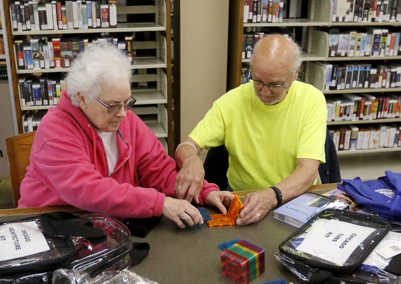 Kathie and Howard Thorson of Crystal Lake check out a Chicago architecture memory kit on Tuesday, Aril 18, 2023, as he try out some new activities that will be available at the the library's Memory Cafe.  Kathie is living with memory issues and Howard, a Vietnam veteran, has stepped into the role of her caretaker.