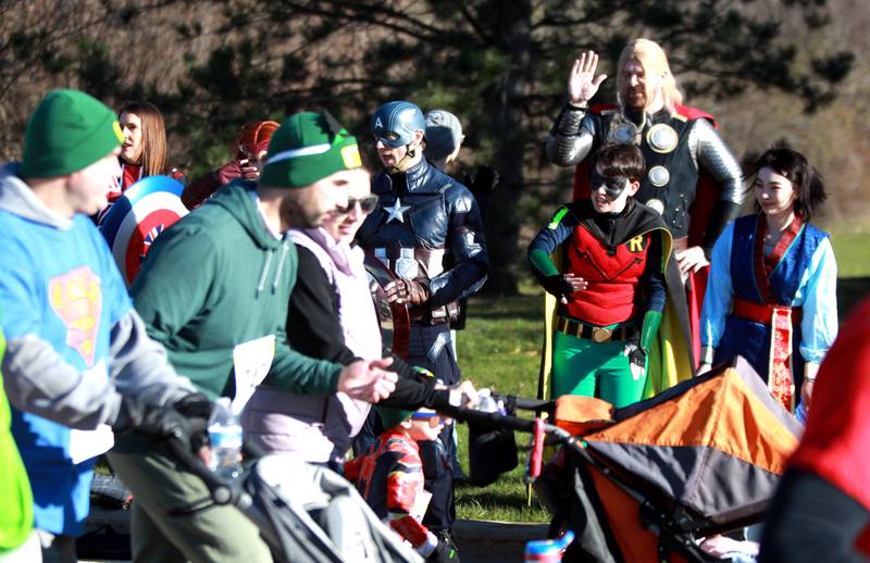 Super Heroes including Captain America and Thor cheer on runners as they take off at the start of the Wheaton Park District’s Superhero 3K Fun Run at the Sensory Garden Playground in Lisle on Saturday, April 6, 2024.