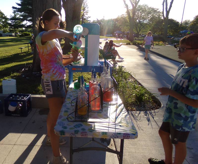 Joey Siena of Tropical Sno Two Rivers adds the flavoring for a snow cone Thursday, Aug. 11, 2022, during the La Salle/Putnam Alliance for Special Education Back to School Bash at Thornton Park in Ottawa.