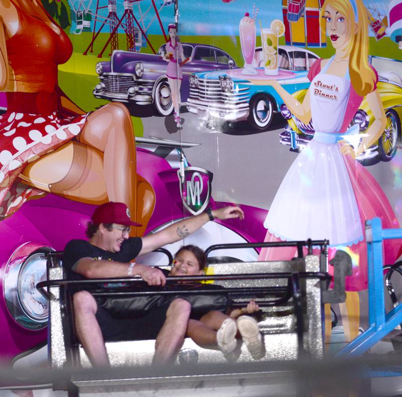 Christian Grogan and his niece, Novalee Currier, 7, of Mt. Morris, take a spin on one of the carnival rides at the Ogle County Fair on Thursday night, Aug. 1, 2024.