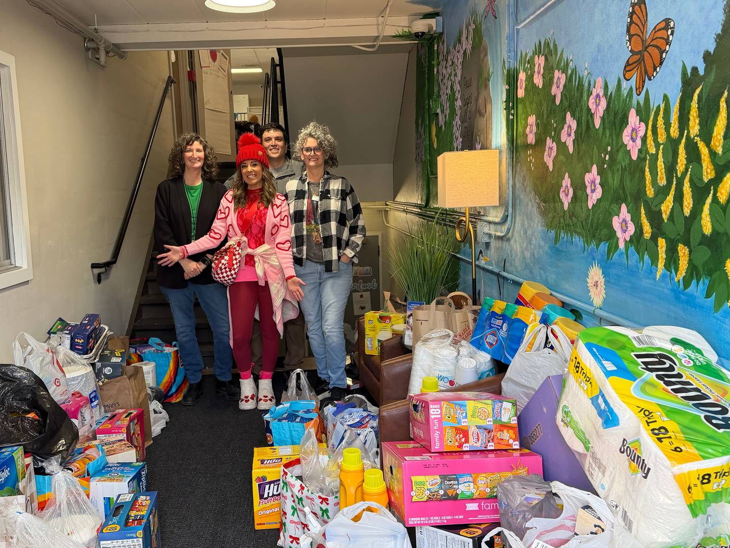 St. Charles educator, Katie Pagni (center, pink) shows off all the collected donations for Lazarus House in St. Charles from participants of her 5k charity run.