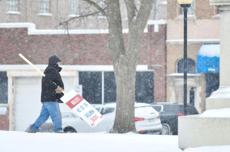 A member of the Concerned Citizens of Manteno returns a sign to his vehicle Tuesday after the group gathered at the Kankakee County Courthouse for a demonstration ahead of the hearing for their case against Gotion, the battery manufacturer opening in Manteno.