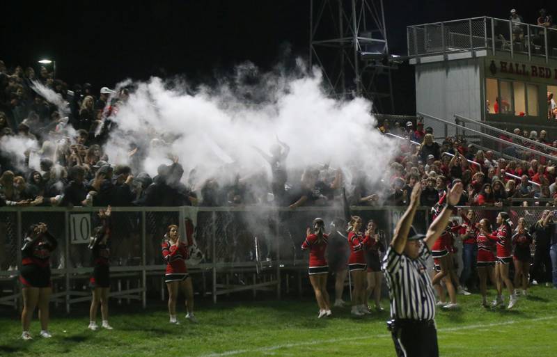 A referee signals a touchdown call as Hall superfans throw baby powder in the air to celebrate while playing Illinois Valley Central on Friday, Sept. 29, 2023 at Richard Nesti Stadium.