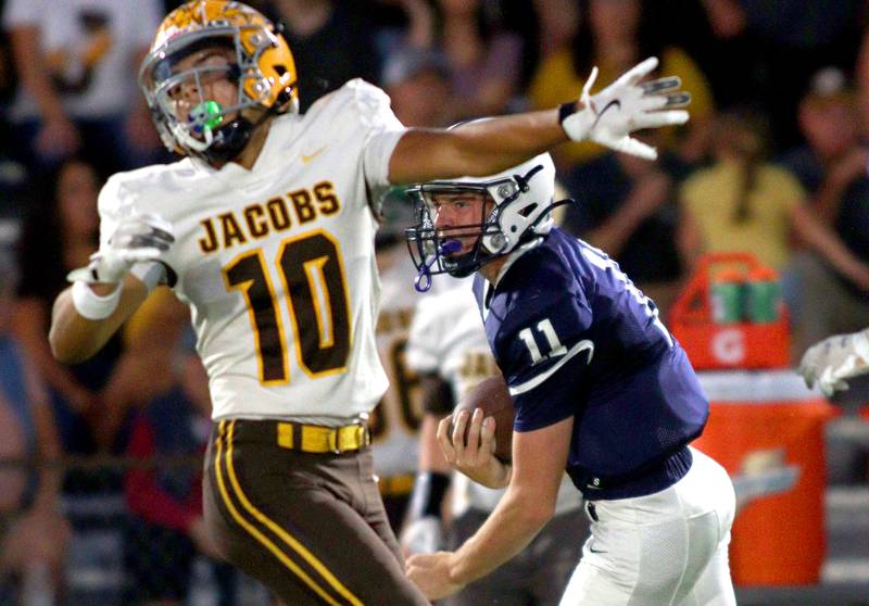 Cary-Grove’s Peyton Seaburg scoots by Jacobs’ Samson Averehi in varsity football on Friday, Sept. 20, 2024, at Al Bohrer Field on the campus of Cary-Grove High School in Cary.
