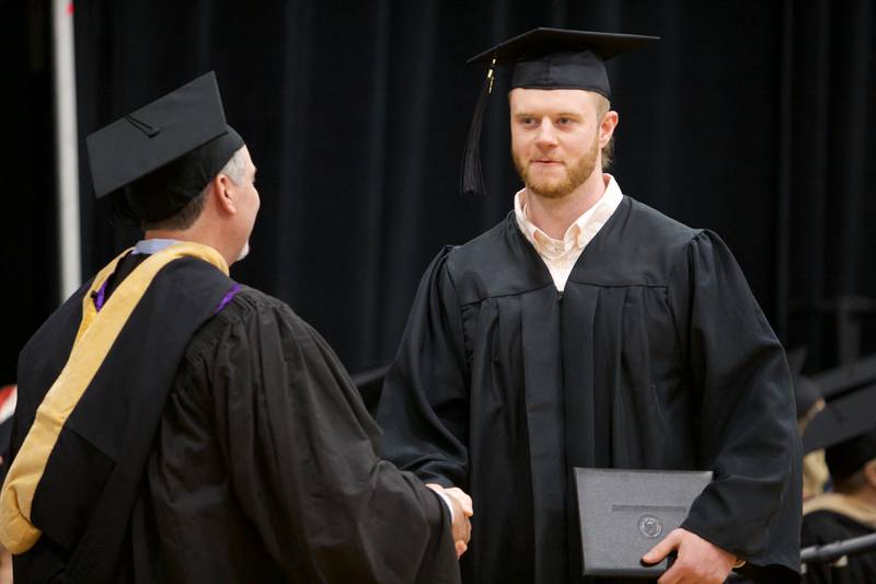 A graduate is congratulated crossing the stage at commencement at McHenry County College on Saturday, May 11, 2024, in Crystal Lake.