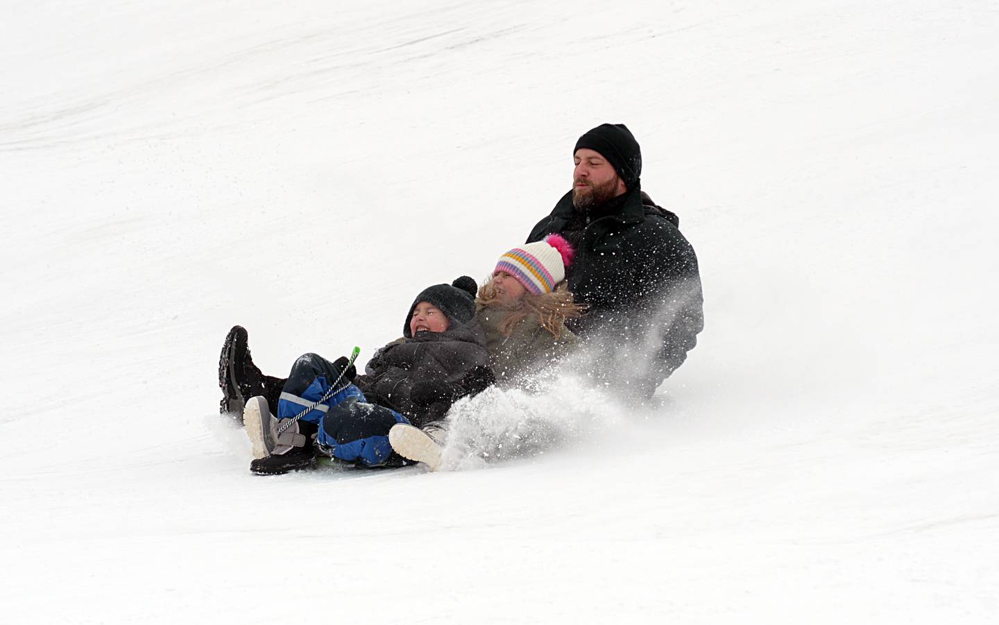 Sergey Kulik of Winfield enjoys sledding with his children Nathan and Naomi at Northside Park in Wheaton despite the negative degree temperatures Saturday, Jan 13, 2024.