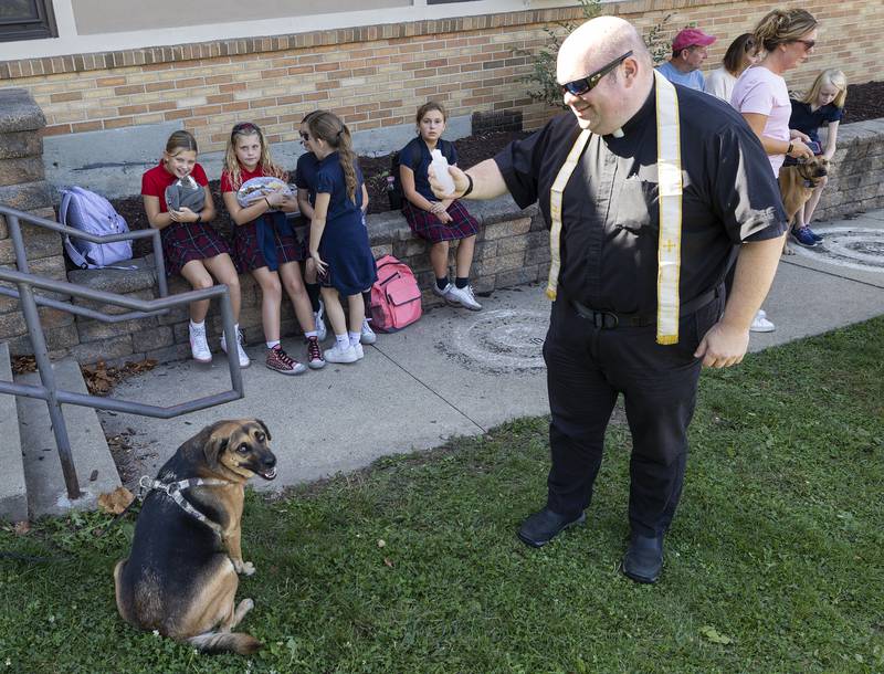 Fr. John Evans blesses a pooch Thursday, Oct. 3, 2024 at St. Mary’s School in Dixon.