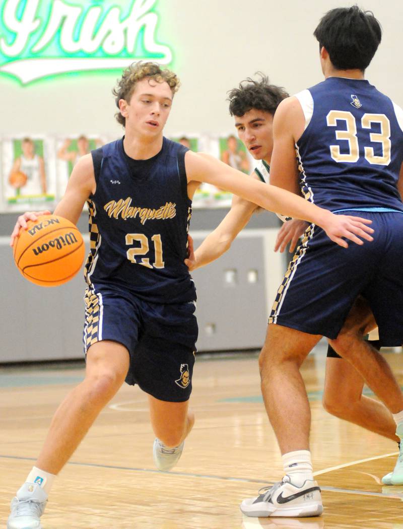 Marquette junior forward Lucas Craig (21) gets past Seneca junior guard Jesus Govea with a screen from teammate Blayden Cassel on Friday, Dec. 5, 2025 at Seneca High School.