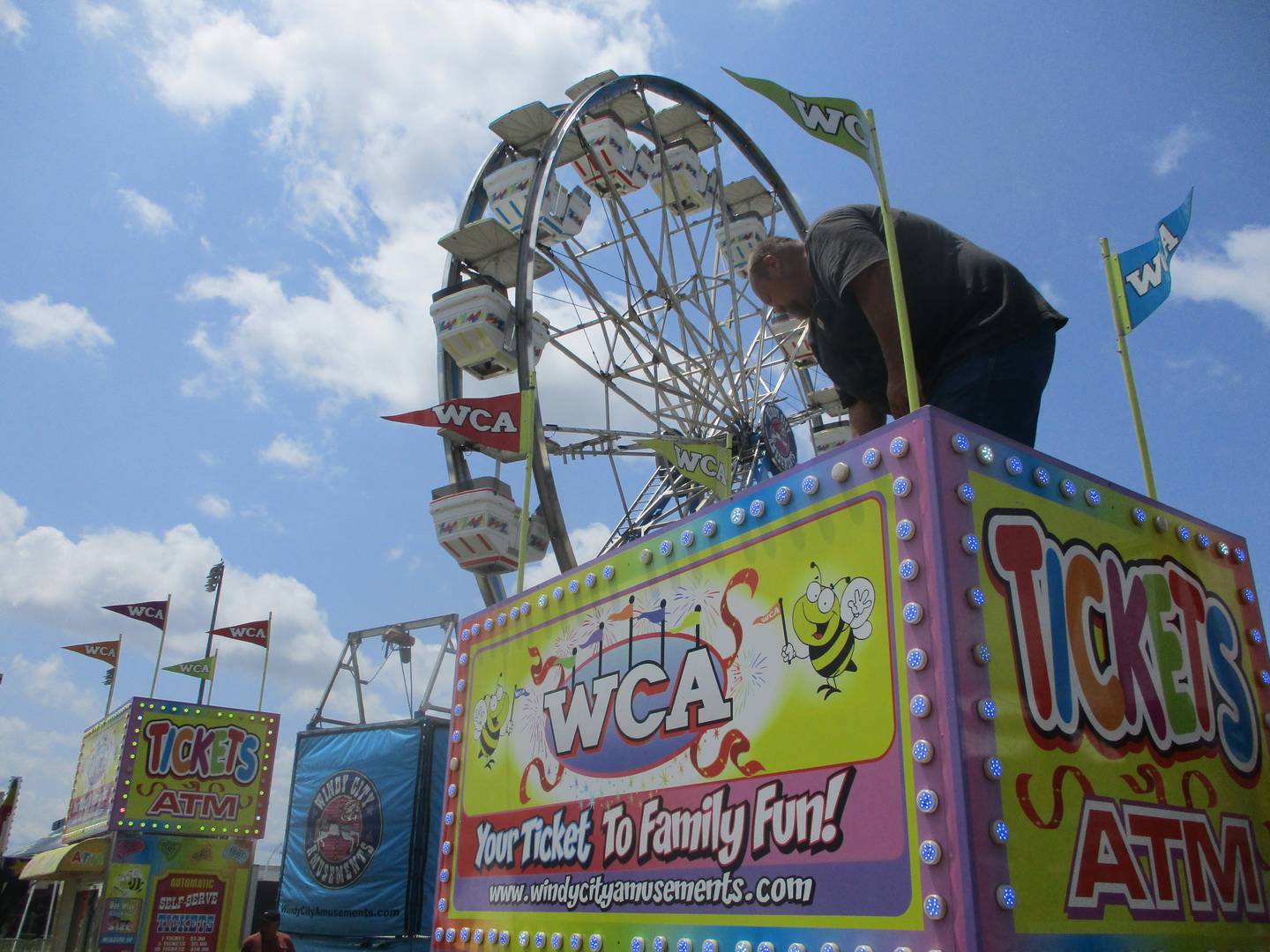 Windy City Amusements employee Phil Lehrfield works on the roof of a carnival stand, getting it ready Thursday for the start of Taste of Joliet. June 19, 2025