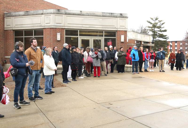 Attendees stand quietly as the bell tolls Tuesday, Feb. 14, 2023, during the remembrance ceremony at the memorial outside Cole Hall at Northern Illinois University for the victims of the mass shooting in 2008. Tuesday marked the 15th year since the deadly shooting took place on campus which took the lives of five people.