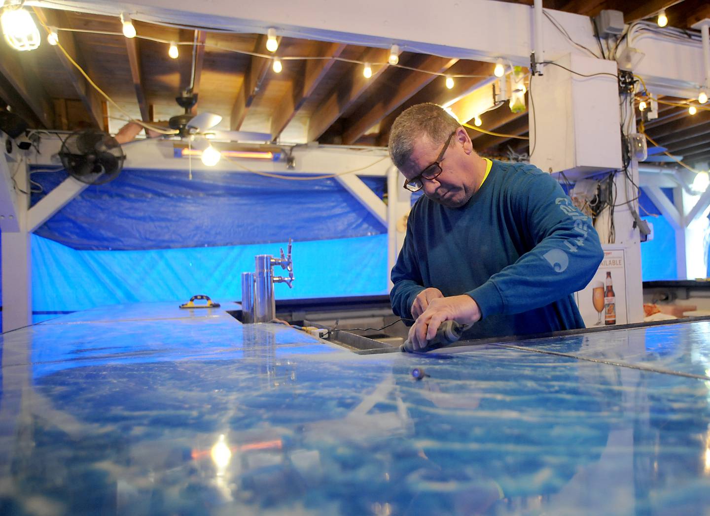 Tim Kautz puts the finishing touches on the outdoor bar counter tops Wednesday, May 4, 2022, at Port Edwards, 20 W. Algonquin Road in Algonquin. With warmer weather in the forecast, Port Edwards is busily preparing for the upcoming summer boating season.