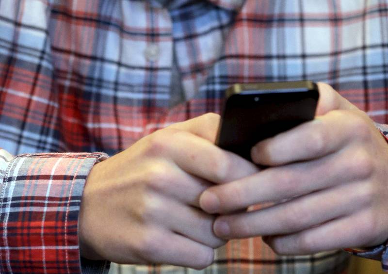 A youth checks his smartphone Oct. 24 in Glenview, Ill. Local police may be tracking your cell phone. But they're regularly censoring information about how the technology ís used or how much it costs taxpayers.