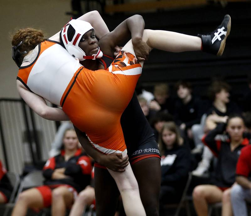 Huntley’s Janiah Slaughter lifts McHenry’s Kaitlynn Mann during the 105-pound match of a Fox Valley Conference girls wrestling match Thursday, Jan. 11, 2024, at McHenry High School.