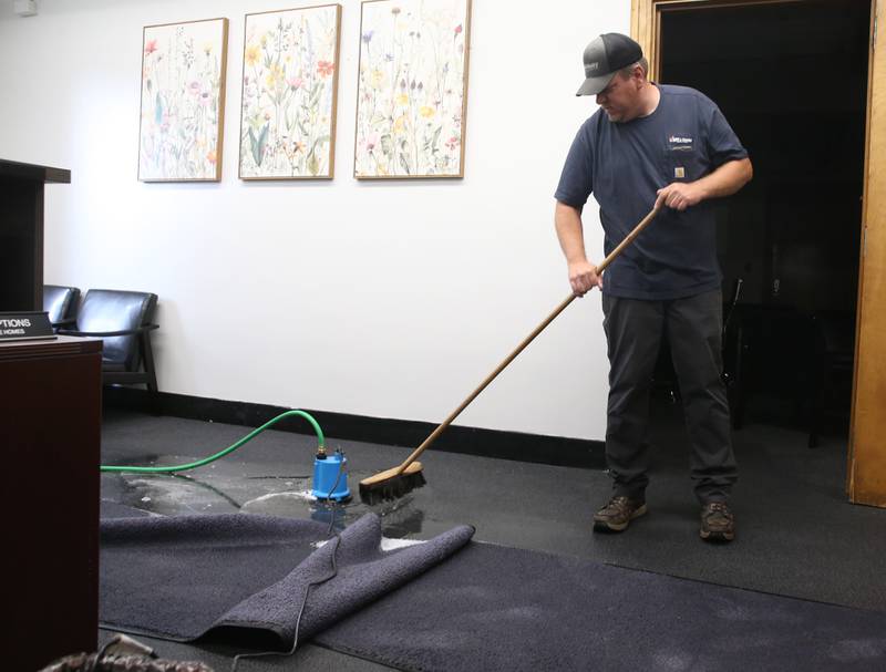 Jason Orabutt with Town and Country Services, pushes standing water into a pump inside the basement of the Bureau County Courthouse on Friday, July 11, 2025 in Princeton. Princeton received over 4 inches of rain from the storm system that sent winds and heavy precipitation to the area.