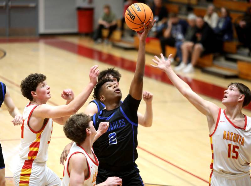 St. Charles North’s Euniel Mondesir reaches for a rebound during a game against Batavia on Wednesday, Dec. 11, 2024 in Batavia.
