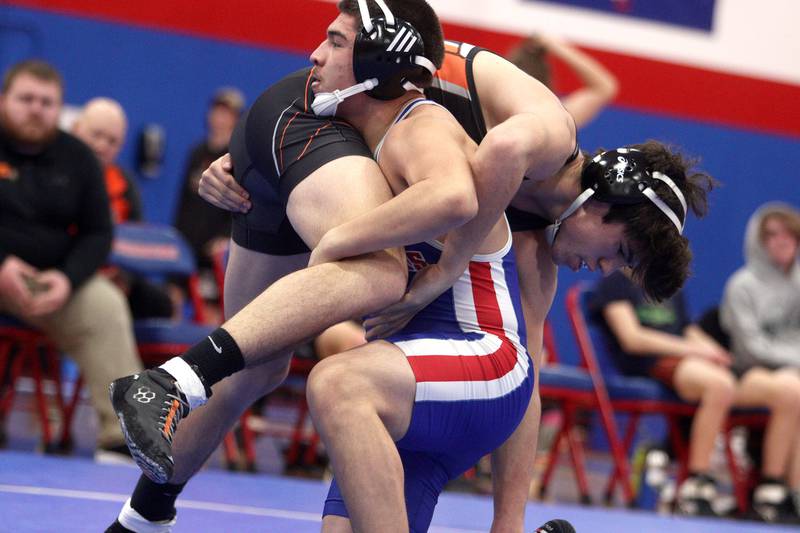 McHenry’s Aiden Fischler is hoisted by Dundee-Crown’s Jose Gavina at 160 pounds in varsity wrestling at Carpentersville Thursday night.