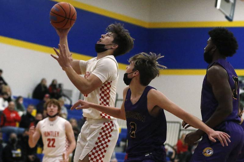 Huntley's Chet Andrews, left, shoots a layup around Wauconda's Justin Drobnik, front, and Garrison Carter, right, during their Johnsburg/Richmond-Burton Thanksgiving Tournament boys basketball final at Johnsburg High School on Friday, Nov. 26, 2021.  Huntley won the final 59-43.