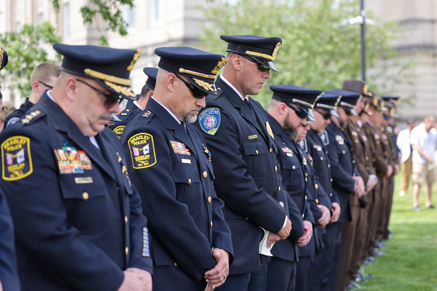 Bradley Police Deputy Chief Adrian Provost, second from left, bows his head in prayer alongside fellow officers during the annual Law Enforcement Officers Memorial Ceremony honoring Kankakee County officers, held on the lawn of the Kankakee County Courthouse on Thursday, May 15, 2025.