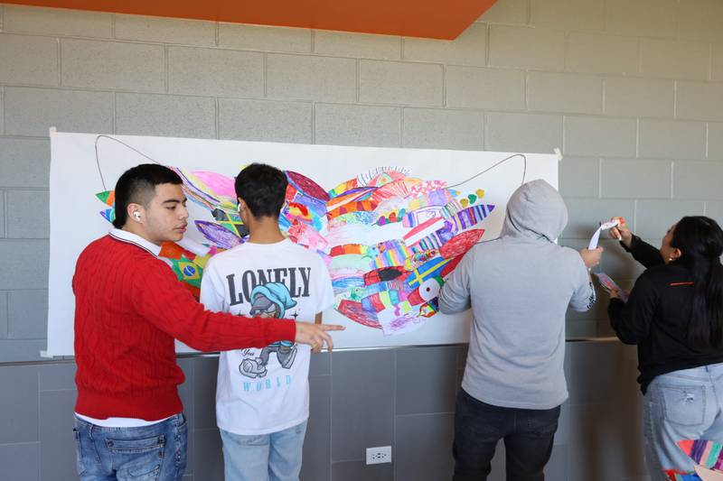 McHenry High School multilingual students decorate a wings mural to use in a "photo booth" area for participants at the April 6 Multicultural Fair. The free event features food vendors, businesses and other organizations to celebrate the variety of cultures in the area.