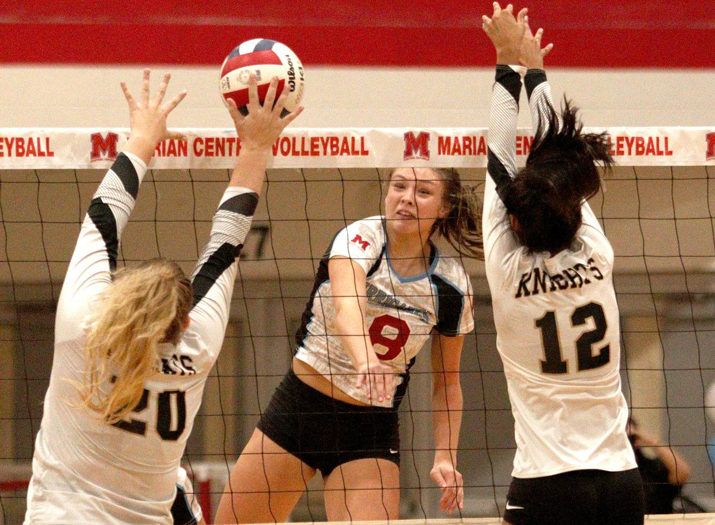 Marian Central’s Ella Conlon sends the ball over the net against Grayslake North in girls volleyball in Woodstock Monday.