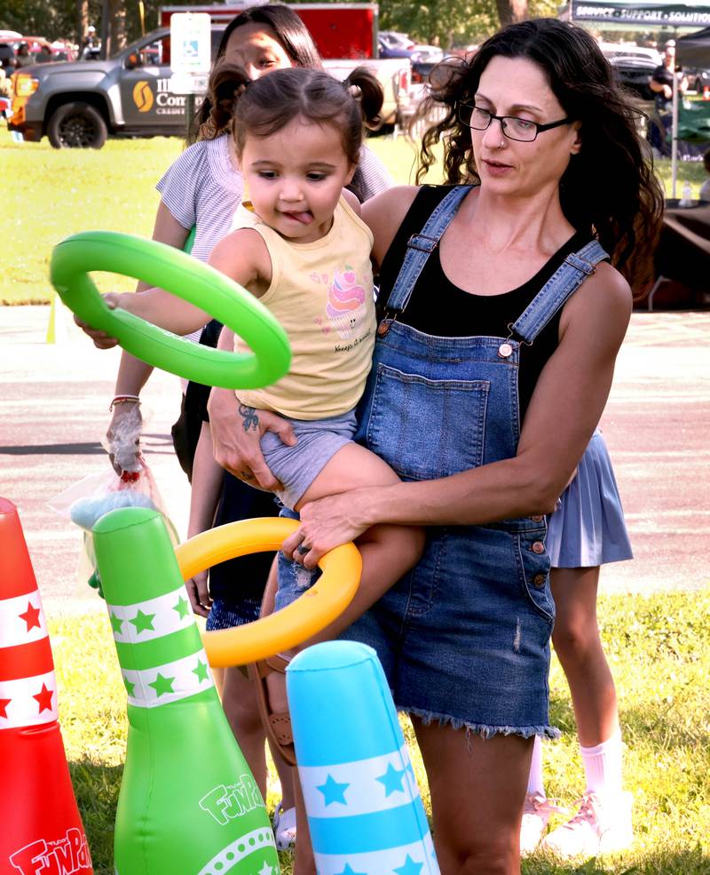 Jetta Thompson, 2, tosses a ring as her grandma Therese Muir, from Sycamore holds her at the Family Fun Fest Wednesday, July 17, 2024, at Hopkins Park in DeKalb.