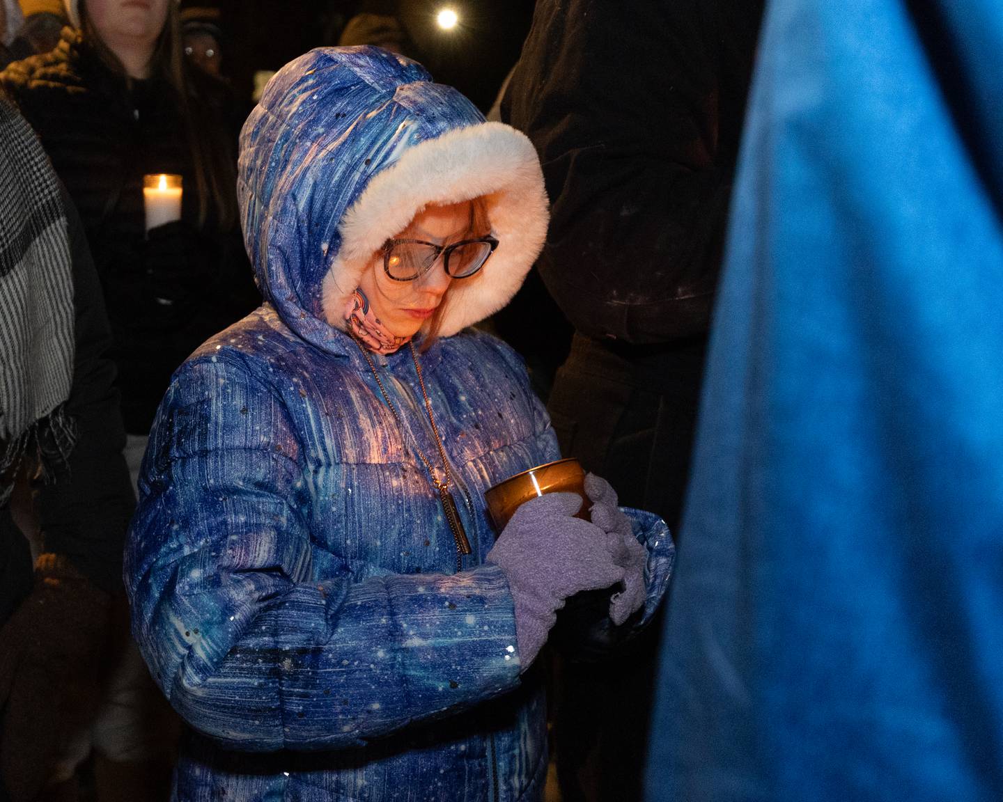 Child looks down at candle honoring those who've died in the Minneapolis protests on Wednesday, January 29, 2026 at 1004 Columbus Street in Ottawa. The Vigil was organized by Illinois Valley Indivisible in light of the recent deaths caused by ICE agents in Minneapolis, Minnesota.