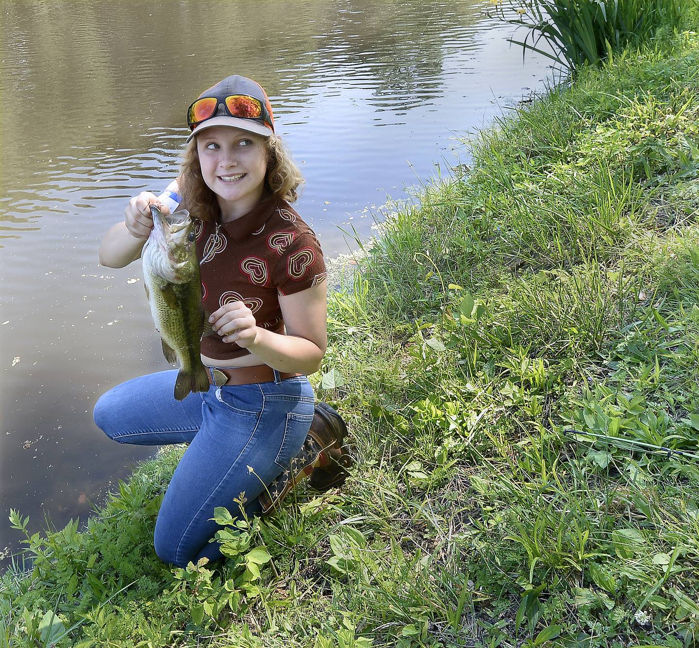 LeAnn Oleson shows the other anglers along the bank of the canal her 15-inch bass she pulled in Saturday, June 3, 2023, during the 36th annual Kid's Fishing Tournament at Lock 14 in La Salle.