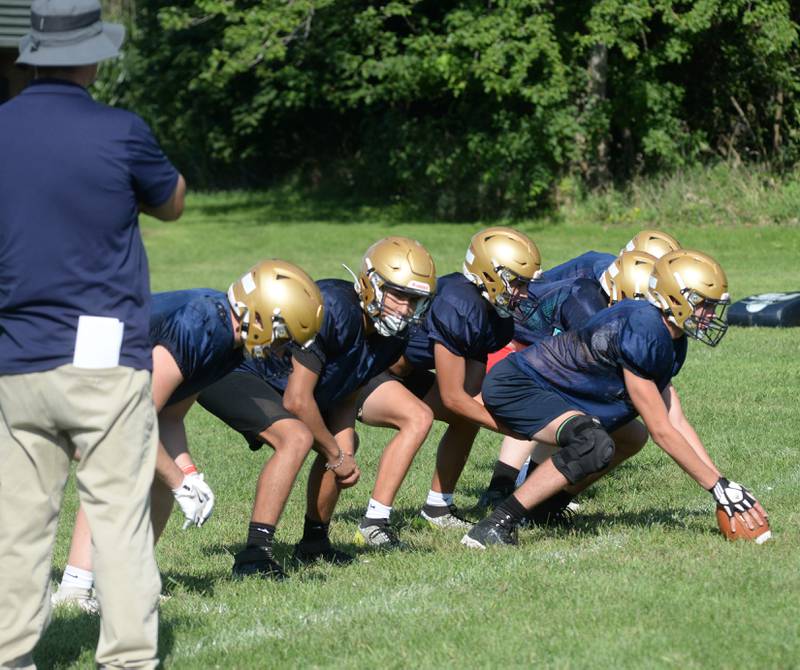 Polo High School players line up to snap the ball during offensive drills as head coach Ted Alston watches on Wednesday, Aug. 13, 2025 in Polo.