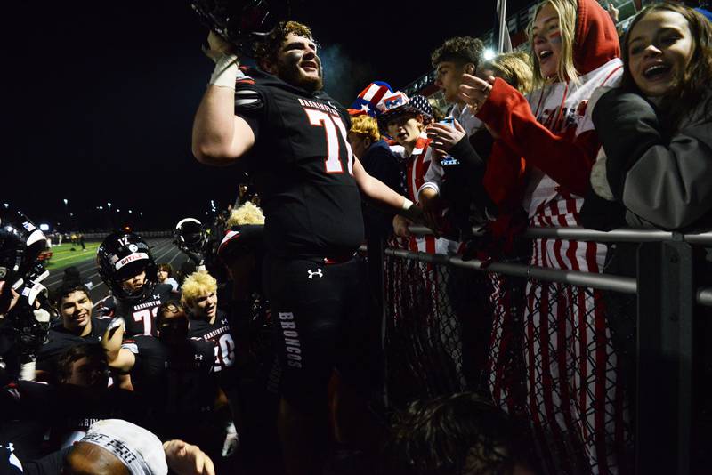 Joe Lewnard/jlewnard@dailyherald.com
Barrington’s Dylan Balsis and his Broncos teammates celebrate their 42-40 victory over Maine South with fans in the student section during the Class 8A football quarterfinal game at Barrington Saturday.