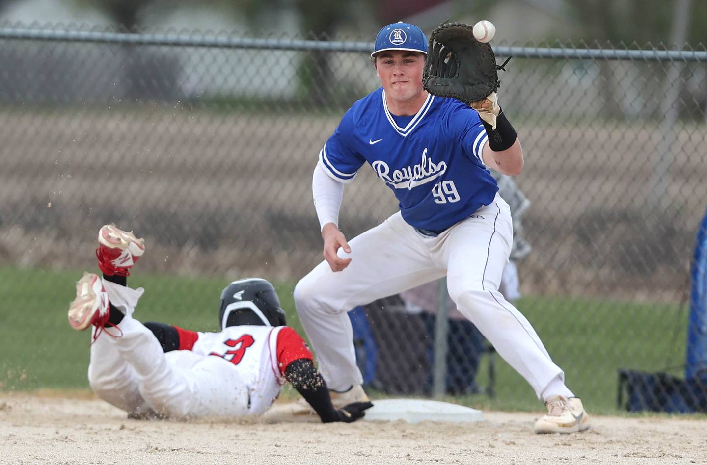 Indian Creek's Tyler Bogle dives back safely on a pickoff attempt as Hinckley-Big Rock's Martin Ledbetter takes the throw during their game Monday, May 1, 2023, at Indian Creek High School in Shabbona.