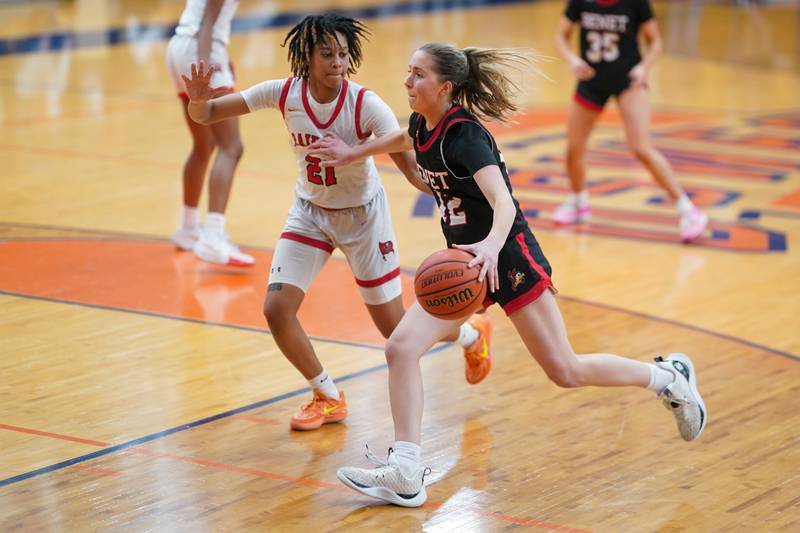 Benet’s Lindsay Harzich (12) drives to the hoop against Bolingbrook's Persais Williams (21) during a Oswego semifinal sectional 4A basketball game at Oswego High School on Tuesday, Feb 20, 2024.