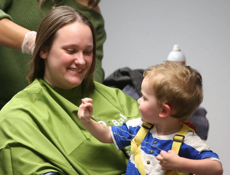 Kassandra Haff, of Ottawa, holds her son Oliver while shaving her head during the first ever St. Baldrick's event on Wednesday, April 30, 2025 at Illinois Valley Community College.