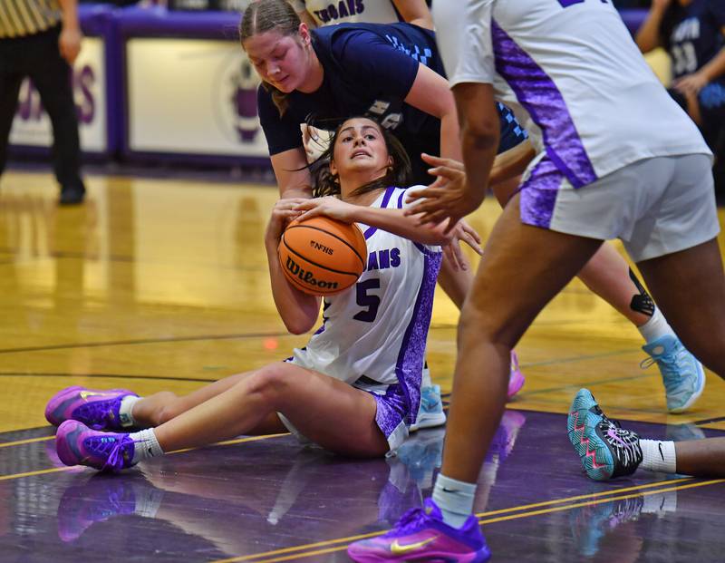Downers Grove North’s Campbell Thulin is tied up by Downers Grove South’s Megan Ganschow during a game on December 20, 2025 at Downers Grove North High School in Downers Grove.