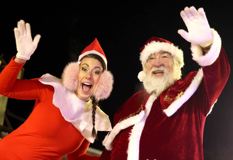 Santa Claus and Elfie wave to kids Thursday, Dec. 5, 2024, in front of the Egyptian Theatre during the DeKalb Chamber of Commerce’s Lights on Lincoln and Santa Comes to Town.