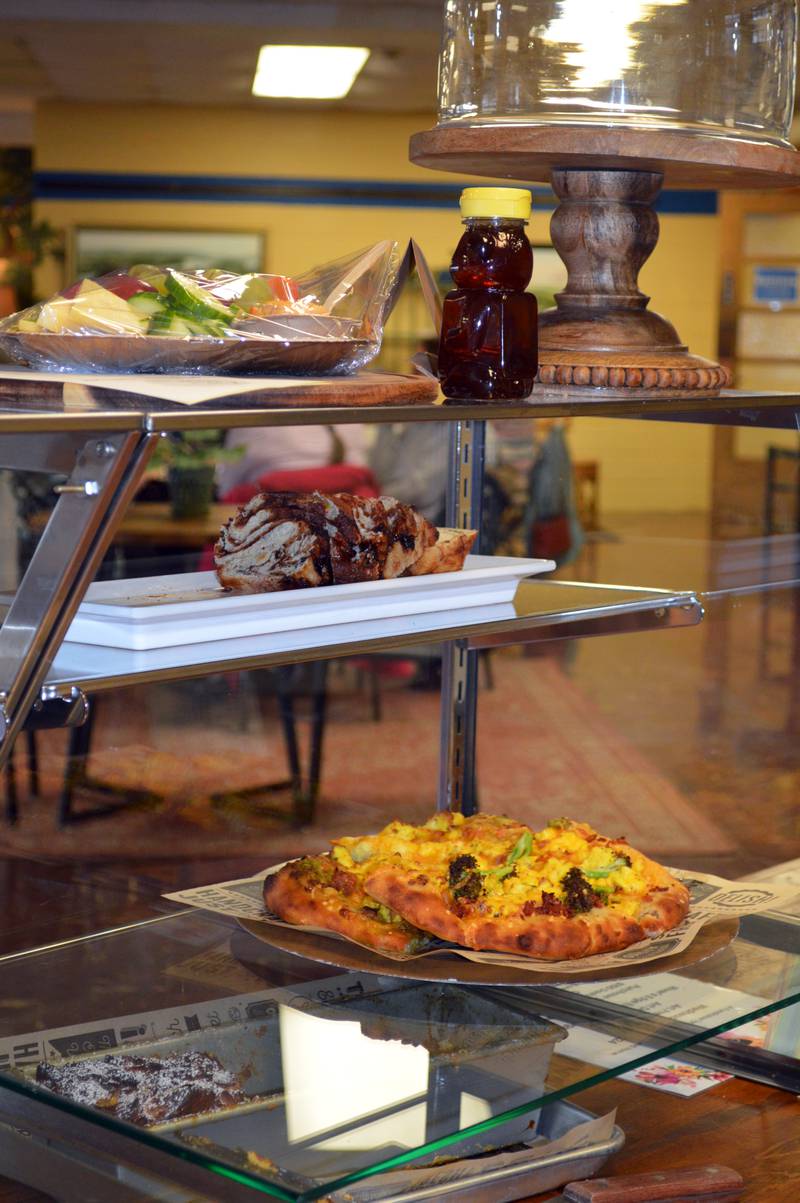 A charcuterie board, a jar of honey, sliced cinnamon raisin swirl bread and a quiche wait in the display case at Jen's Artisan Breads to be sold and eaten on Friday, Feb. 16, 2024. Jen's Artisan Breads is located in Mount Morris in the former David L. Rahn Junior High School.